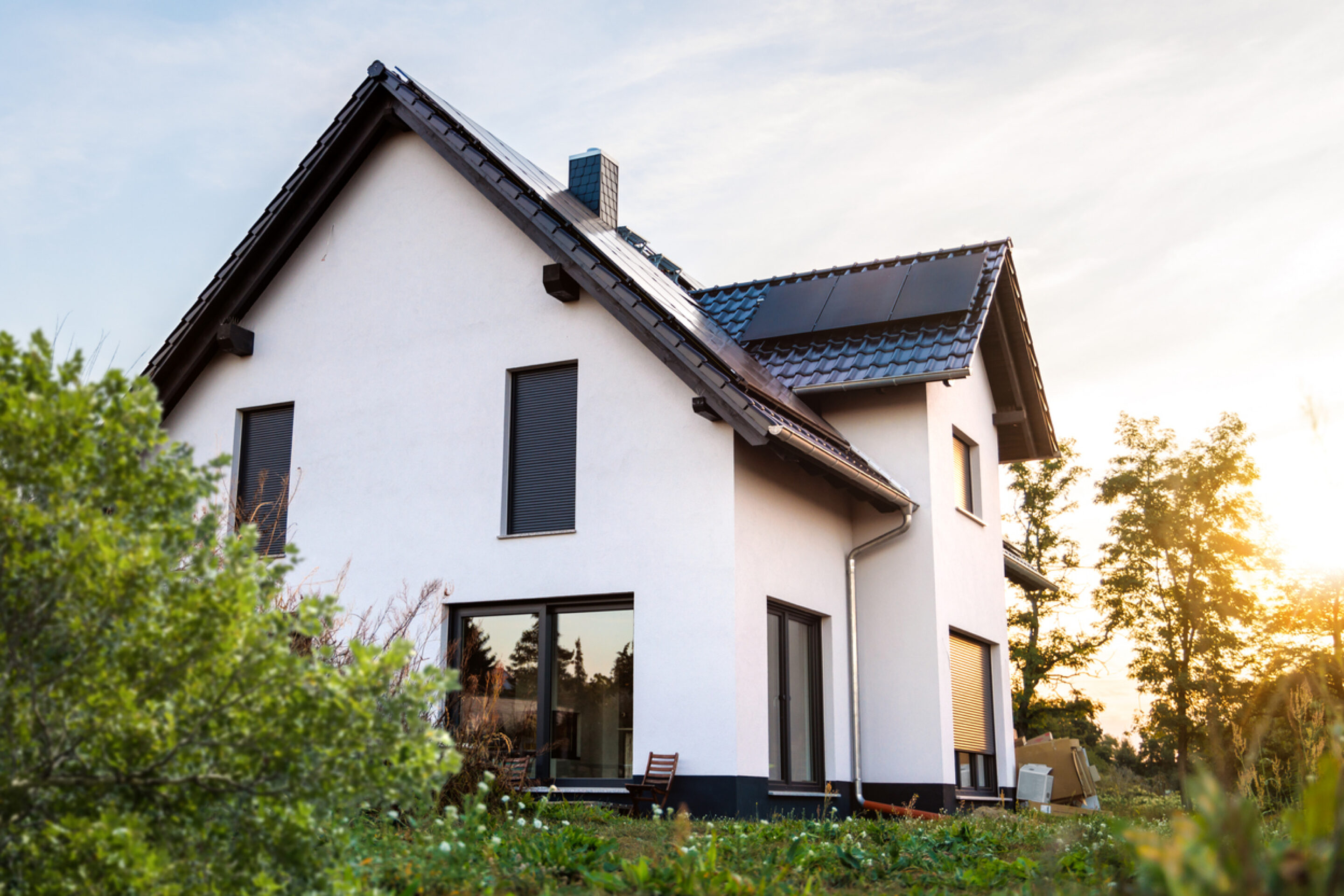 Haus mit Grünem garten und PV panele auf dem Dach 